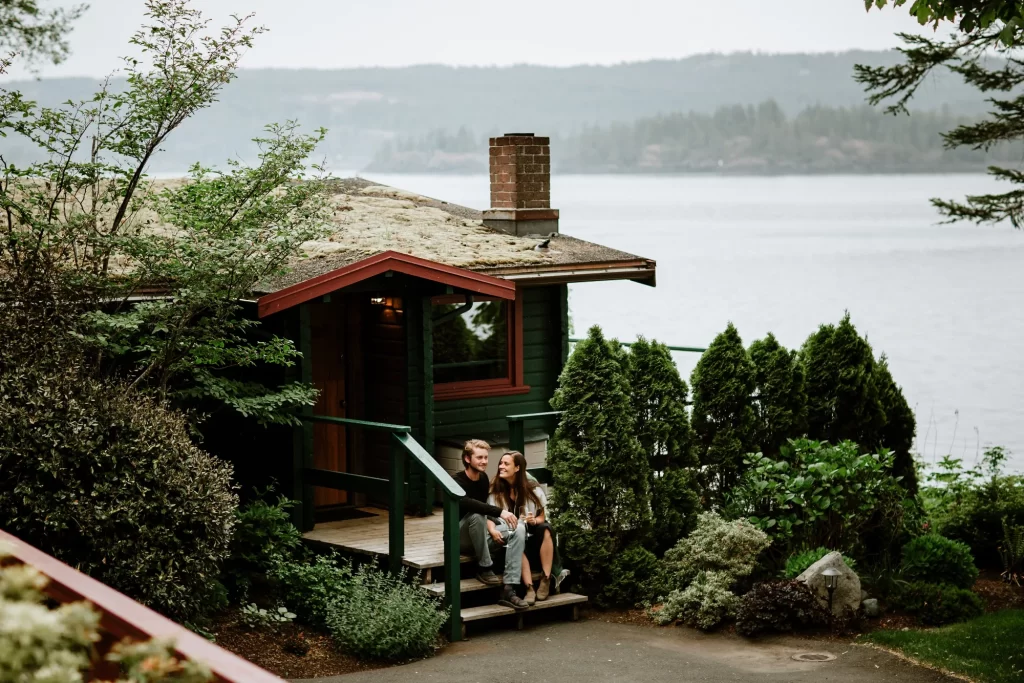 a couple sitting by a coastal cottage