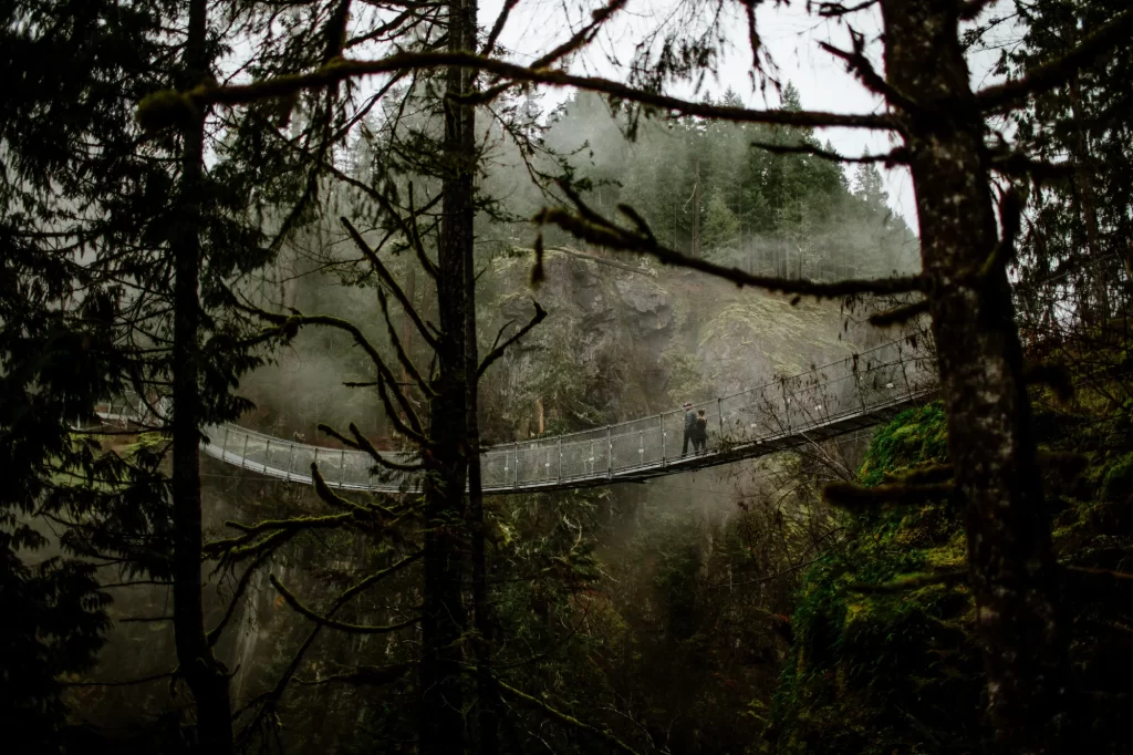 a couple walking on the suspension bridge on a foggy day